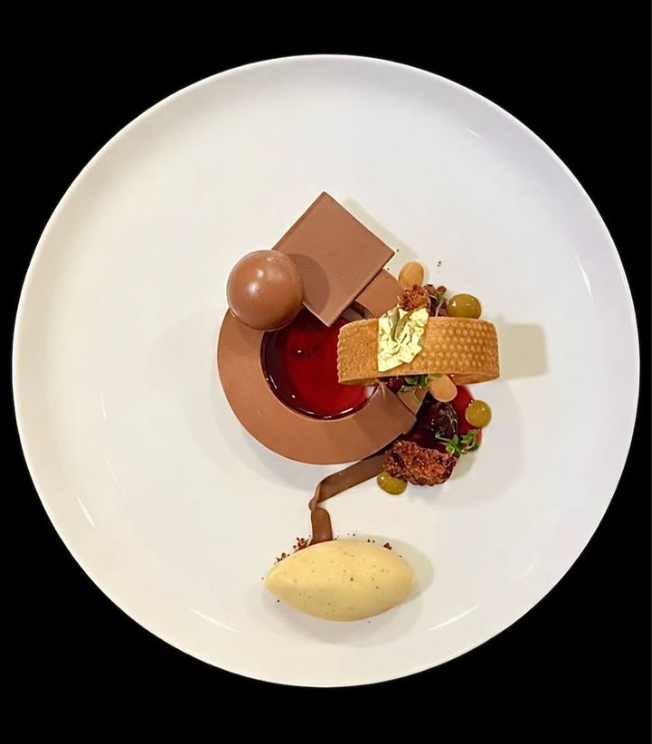 Chocolate plated dessert with red fruit
