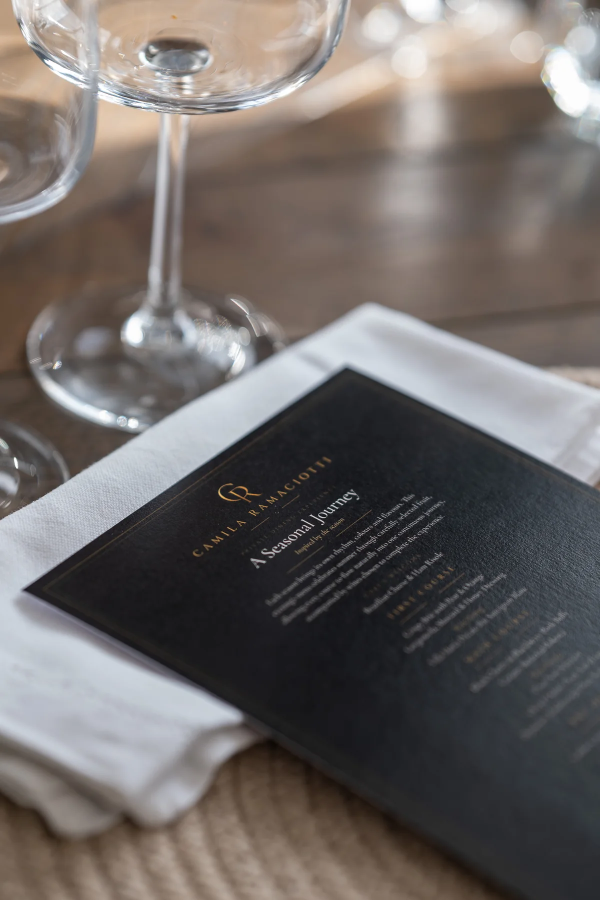 Camila Ramaciotti private dining menu beside glassware at the table